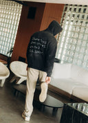Model in the cream vintage-wash Safe Spaces Hoodie with frayed details, front view