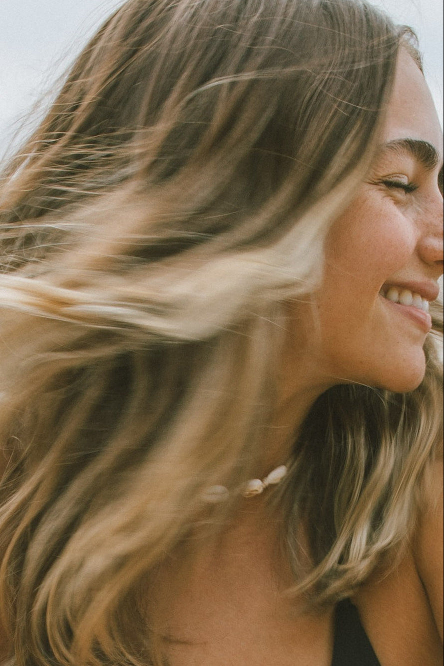Woman with blonde hair smiling outdoors